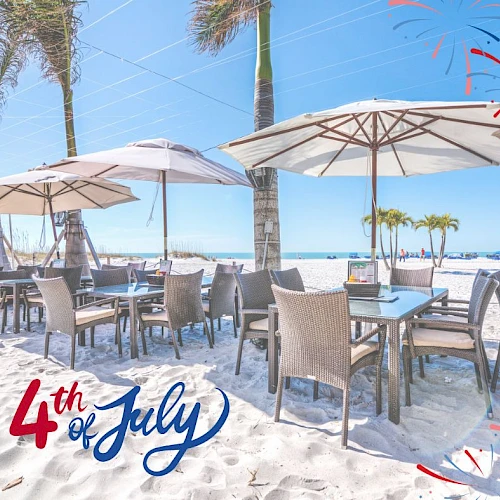 An outdoor beach dining area with umbrellas, palm trees, and the text "4th of July" with fireworks graphics in the corner of the image.